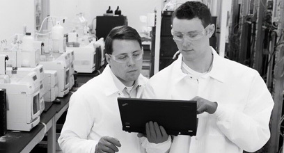 Two lab technicians reading a tablet