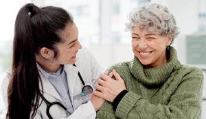 Female doctor speaking to elderly female patient